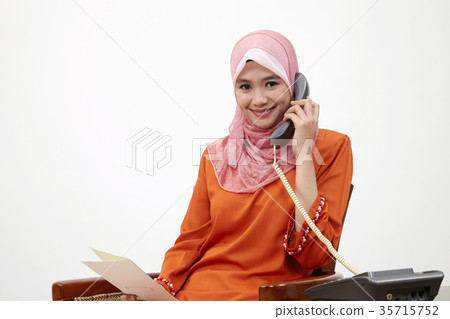 malay girl with tudung talking with land line phone 35715752