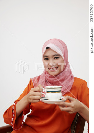 malay girl with tudung holding cup of hot tea 35715760