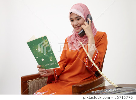 malay girl with tudung talking with land line phone 35715776