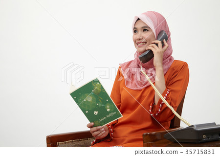 malay girl with tudung talking with land line phone malay girl with tudung talking with land line phone 35715831
