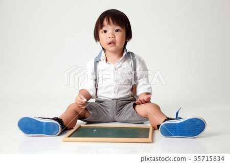 boy sitting holding chalk board boy sitting holding chalk board 35715834
