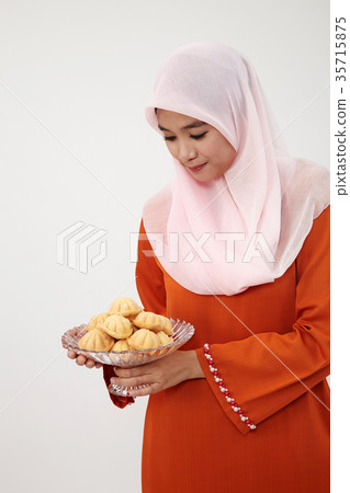 malay girl with tudung with kueh bahulu 35715875