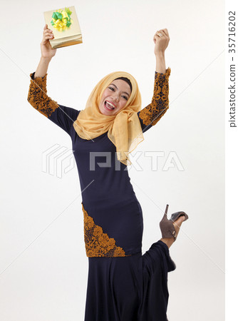 excited woman holding a present 35716202