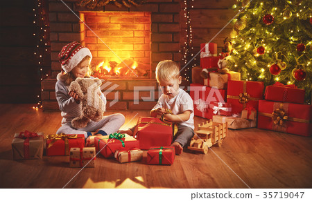 happy children open Christmas gifts at night at Christmas tree happy children open Christmas gifts at night at Christmas tree 35719047