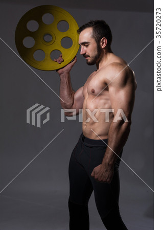 Muscular bodybuilder guy doing exercises with dumbbell 35720273