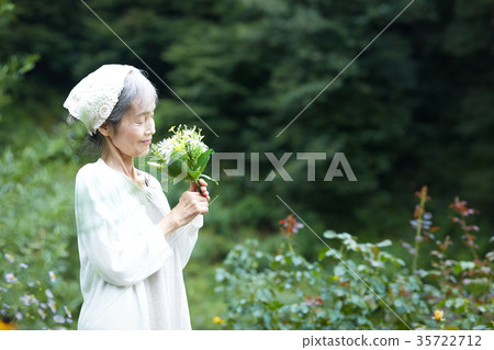 Senior woman smelling the smell of flowers 35722712