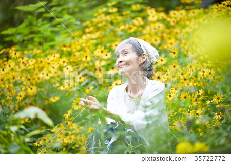 Senior woman relaxing in a flower field 35722772