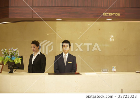 Men and women working in a hotel reception 35723328