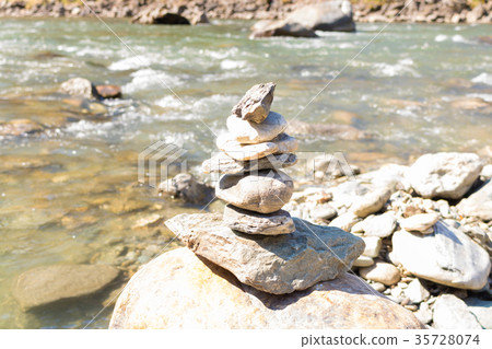 Balanced stone pyramid blue water Mountain River. Balanced stone pyramid blue water Mountain River. 35728074