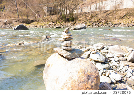 Balanced stone pyramid blue water Mountain River. Balanced stone pyramid blue water Mountain River. 35728076