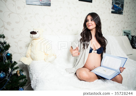 Pregnant woman reading a book at home Pregnant woman reading a book at home 35728244