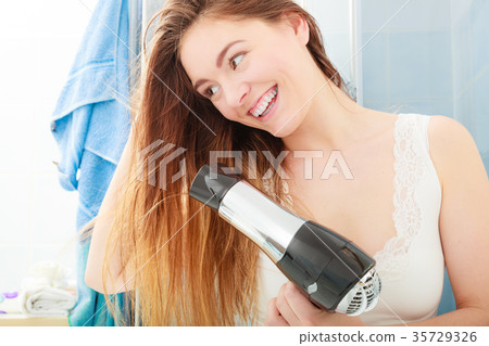 long haired woman drying hair in bathroom long haired woman drying hair in bathroom 35729326