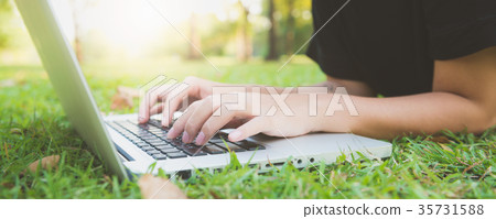 Young asian woman's legs on grass with open laptop Young asian woman's legs on grass with open laptop 35731588