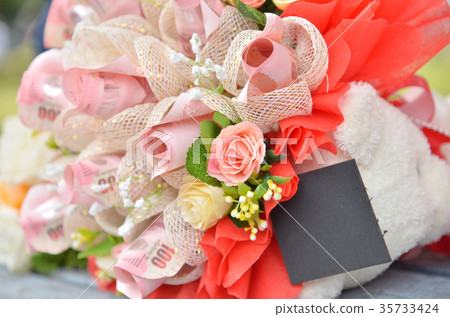 Fake flowers bouquet on wallpaper background Fake flowers bouquet on wallpaper background 35733424