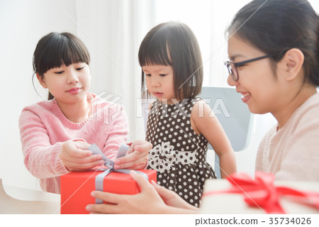 Happy Asian family wrapping a gift box. 35734026