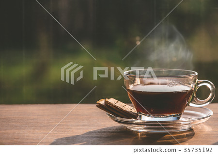 Cup of coffee on the table inside the window Cup of coffee on the table inside the window 35735192