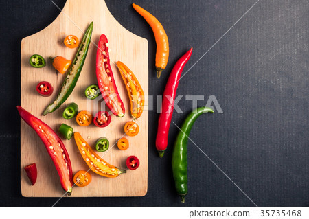 Colorful mix of chili pappers on black background. 35735468