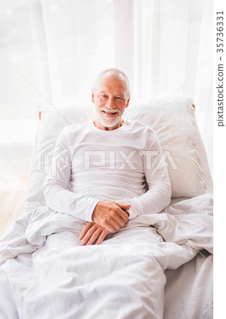 Senior man lying in bed at home. Senior man lying in bed at home. 35736331