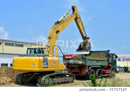 Hydraulic excavator loading dirt into a dump Hydraulic excavator loading dirt into a dump 35737587