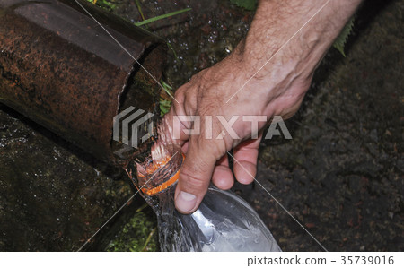 A man's hand holds a plastic bottle 35739016