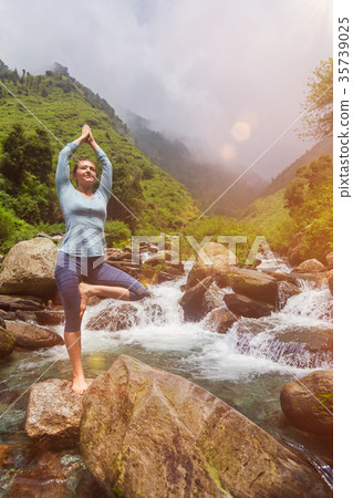 Woman in yoga asana Vrikshasana tree pose at 35739025