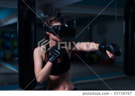 Young fighter boxer fit girl in VR glasses wearing 35739787