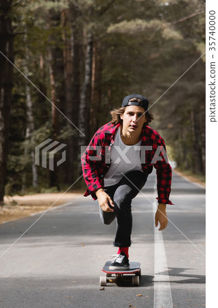 A young hipster in a cap and plaid shirt is riding A young hipster in a cap and plaid shirt is riding 35740000