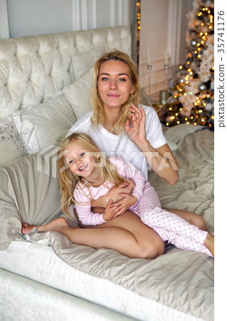 mother sitting with her daughter on the big bed 35741176