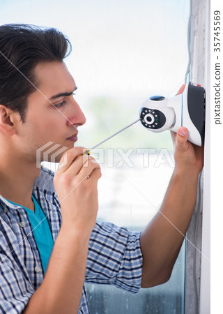 Man installing surveillance CCTV cameras at home Man installing surveillance CCTV cameras at home 35745569