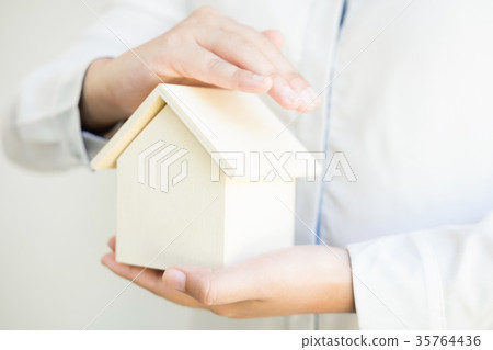 Female hands saving small house, Real estate business. insurance 35764436