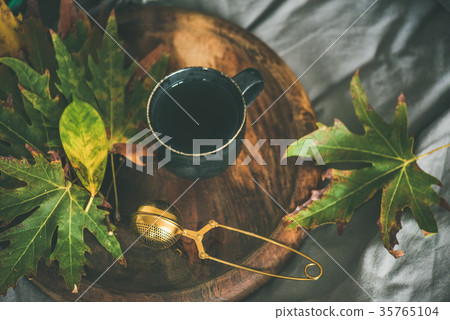 Mug of tea with sieve and colofrul autumn leaves Mug of tea with sieve and colofrul autumn leaves 35765104