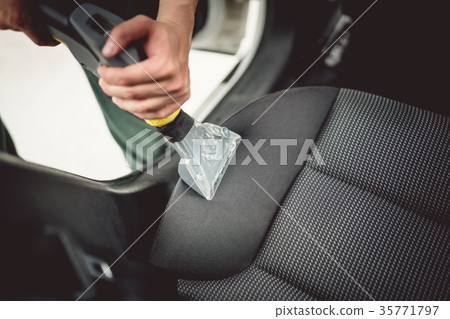 Details of worker vacuuming leather car interior Details of worker vacuuming leather car interior 35771797