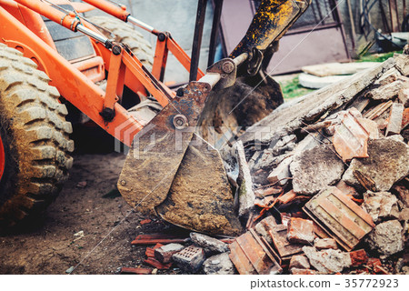 bulldozer demolishing concrete brick walls 35772923