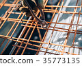 Construction worker hands securing steel bars 35773135