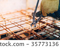 worker using pliers and securing steel bars 35773136