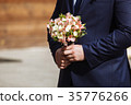young handsome groom in a dark blue suit standing 35776266