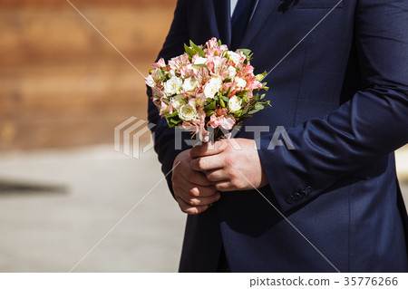 young handsome groom in a dark blue suit standing 35776266
