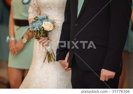 Beautiful wedding couple, bride and groom holding Beautiful wedding couple, bride and groom holding 35776306