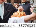 Groom holding slice of traditional wedding round 35776325