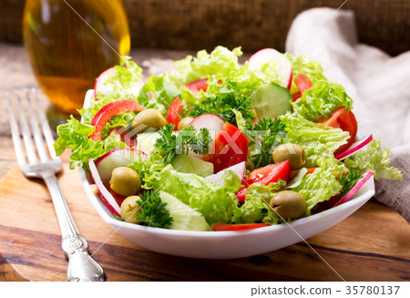 bowl of fresh salad with vegetables and greens 35780137