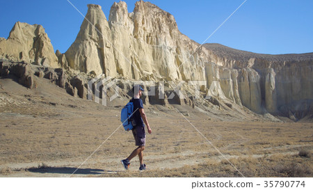 a young traveler walks along a path in a a young traveler walks along a path in a 35790774