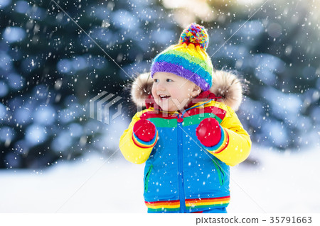 Child playing with snow in winter. Kids outdoors. Child playing with snow in winter. Kids outdoors. 35791663
