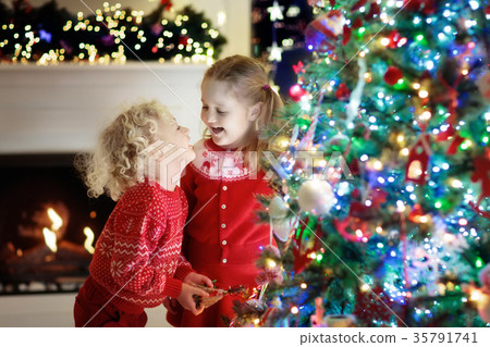 Children at Christmas tree. Kids at fireplace  35791741