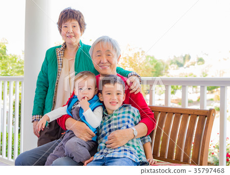 Senior Adult Chinese Couple Sitting With Their Mixed Race Grandc 35797468
