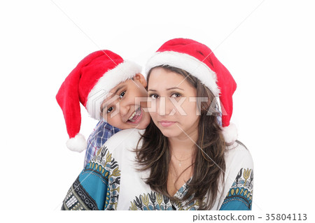 Cheerful boy and woman in Santa Claus hat. Cheerful boy and woman in Santa Claus hat. 35804113