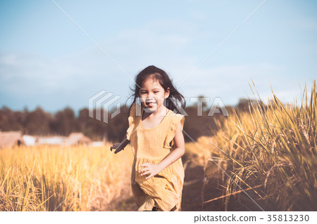 Cute asian girl having fun to run in paddy field Cute asian girl having fun to run in paddy field 35813230