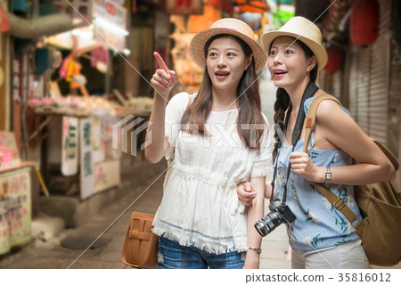 Two Asian girls pointing and walking Two Asian girls pointing and walking 35816012