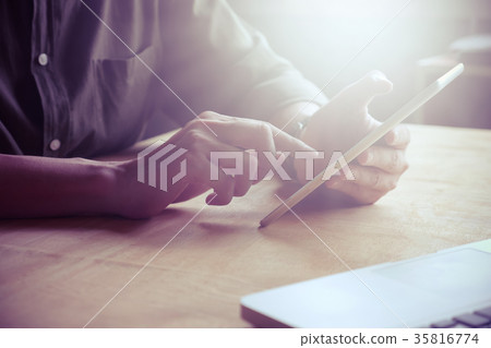 Close up of Male hands using tablet on the table 35816774