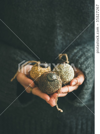 Woman holding golden and silver balls in hands Woman holding golden and silver balls in hands 35827267