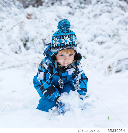 Happy child having fun with snow in winter Happy child having fun with snow in winter 35830054